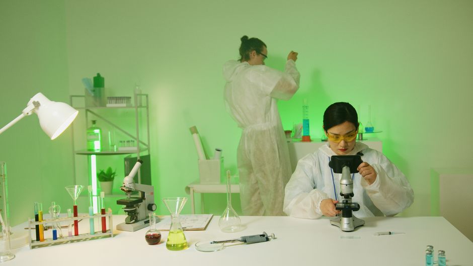 Scientists wearing protective suits conduct research in a modern laboratory setting.
